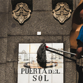 Un operario del Ayuntamiento de Madrid limpia el cartel de la Puerta del Sol-  FERNANDO SANCHEZ