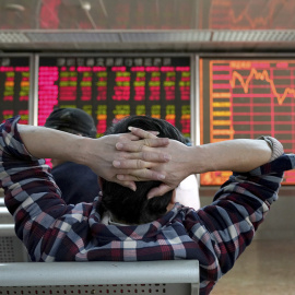 FILE PHOTO: An investor looks at a stock quotation board at a brokerage office in Beijing, China January 3, 2020. REUTERS/Jason Lee/File Photo