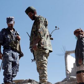 19/01/2022 Soldados pro hutíes vigilan mientras los rescatistas buscan supervivientes de los ataques aéreos de las fuerzas saudís