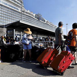Cruceristas esperando a los taxis después de desembarcar del crucero 'Wonder of the Seas' en el puerto de Barcelona, el24 de julio de 2022.- PAU BARRENA/AFP