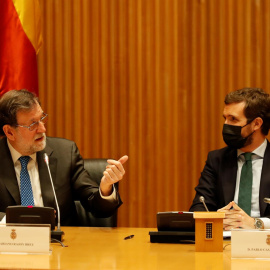 El ex presidente del gobierno Mariano Rajoy (i) y el líder del Partido Popular, Pablo Casado, durante el acto homenaje organizado este jueves por el GPP al que fuera diputado, Carlos Mantilla, en el Congreso de los Diputados en Madrid.