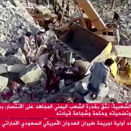 Los equipos de rescate sacan un cuerpo de los escombros después de que un ataque aéreo golpeara un centro de detención temporal en Saada, Yemen, el 21 de enero de 2022.