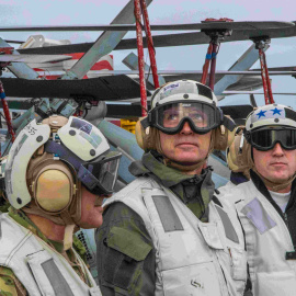 El secretario general de la OTAN, Jens Stoltenberg (C), observa un F-18 Super Hornet aterrizando en el portaaviones USS Harry S. Truman.