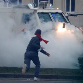 Un manifestante arroja un ladrillo a un vehículo policial durante los enfrentamientos tras una protesta contra las medidas europeas contra el coronavirus, en Bruselas.
