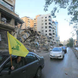 Ciudadanos ondean la bandera de Hizbulá mientras conducen por los suburbios del sur de Beirut, a 27 de noviembre de 2024.