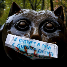 Una mascarilla de fabricación casera con la advertencia ‘’Quedate en casa’’ protege la boca de la escultura "El gato", del escultor colombiano Fernando Botero, en la Rambla del Raval de Barcelona, este lunes en el que los españoles encaran 