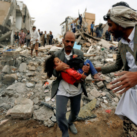 Un hombre lleva en brazos a una niña herida en un bombardeo de la coalición saudí contra Yemen en agosto de 2017. Khaled Abdullah / REUTERS