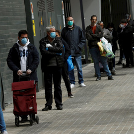 Varios clientes guardan cola para entrar en un supermercado de la Gran Via de Barcelona, este miércoles, cuando se cumple el undécimo día del estado de alarma decretado por el Gobierno por la pandemia de coronavirus. EFE/Toni Albir
