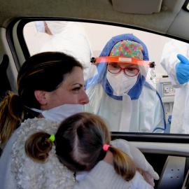Una mujer y su hija se someten a un test para detectar el coronavirus desde su coche en la ciudad de Pozzuoli, cerca de Nápoles (Italia) /EFE