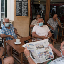 Un grupo de amigos con mascarilla desayuna en un bar de la localidad de Es Mercadal, Menorca | EFE