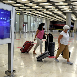 Dos pasajeras con maletas en la terminal T1 del Aeropuerto de Madrid-Barajas Adolfo Suárez, en Madrid (España), a 27 de julio de 2020. Desde ayer está en vigor la orden del gobierno del Reino Unido que impone a los viajeros procedentes de E