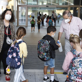 Personal del colegio Aldapeta María Ikastetxea aplica este lunes gel hidroalcohólico a los alumnos. EFE/ Juan Herrero