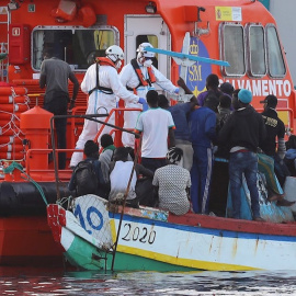 El personal de Salvamento Marítimo ayuda a los inmigrantes a desembarcar en el puerto de Arguineguín.