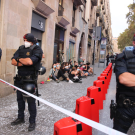 El cordó policial en primer terme i de les persones concentrades a les portes d'un habitatge per evitar el desnonament. Miquel Codolar | ACN