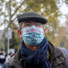 Un hombre lleva una mascarilla donde se lee "defiende tu sanidad 100% pública" durante una manifestación de la Marea Blanca en Madrid, a 29 de noviembre de 2020.