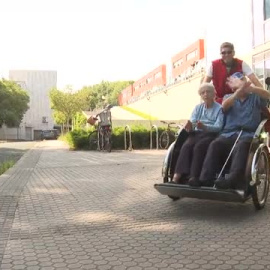 Un grupo de voluntarios pasea a ancianos de residencias de San Sebastián en triciclos