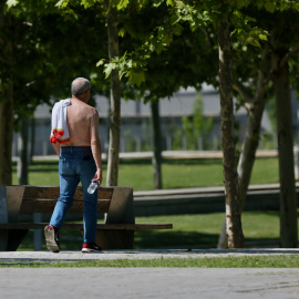 19/5/22-Un hombre camina sin camiseta el día en que España ha comenzado a sufrir un "importante" episodio cálido con temperaturas de pleno verano, a 17 de mayo de 2022, en Madrid (España).