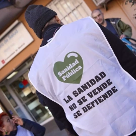 Un hombre con un chaleco en el que se lee: 'La Sanidad no se vende, se defiende', en la puerta del Centro de Salud de Abrantes, donde se ha instalado una mesa de recogida de firmas para solicitar más médicos en el Centro de Salud de Abrantes