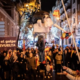 Decenas de personas celebran la entrada del año nuevo en la calle Ferraz golpeando un muñeco de Pedro Sánchez, a 1 de enero de 2024, en Madrid.