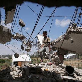 Un niño palestino juega en los escombros de las casas destruidas durante la guerra de 50 días entre Israel y Hamas militantes. AFP./ SAID KHATIB