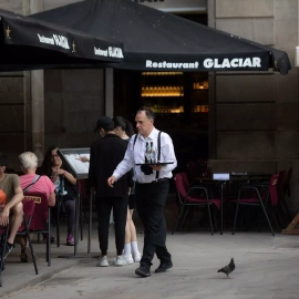 Foto de archivo de un camarero sosteniendo una bandeja en la plaza Real de Barcelona, a 15 de junio de 2022, en Barcelona, Catalunya.
