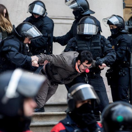 Agentes de los Mossos en el momento en el que desalojan a los manifestantes ante el TSJC. EFE/Quique García