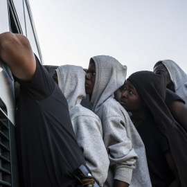 Varios migrantes suben a un autobús de la Guardia Civil para ser trasladados desde el puerto de Algeciras, en agosto de 2018.- JAIRO VARGAS (ARCHIVO)