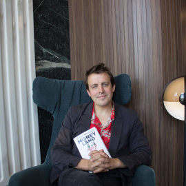 El periodista Oliver Bullough, autor de 'Moneyland', posa con su libro en un hotel de Madrid. (PRINCIPAL DE LOS LIBROS)