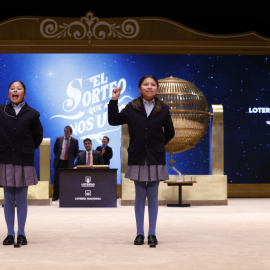 Las niñas de la Residencia San Ildefonso de Madrid muestran el número 40014, el segundo premio del sorteo de la Lotería de Navidad dotado con 1.250.000 euros a la serie.