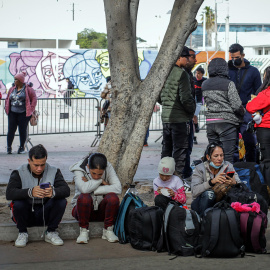 Migrantes deportados descansan en un anden en el puerto fronterizo de El Chaparral, en Tijuana (México), a 22 de enero de 2025.