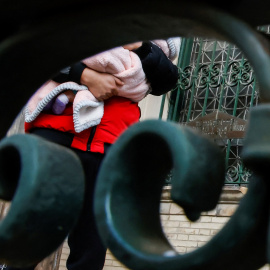 Un hombre sostiene a un bebé mientras espera para entrar a la Iglesia Metodista Unida de San Pablo y San Andrés, en Nueva York.
