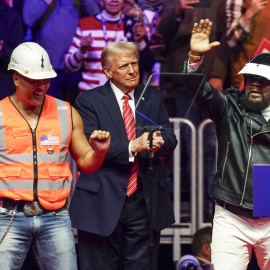 El presidente electo de Estados Unidos, Donald Trump (centro), en el escenario junto a James Kwong (izq.) y Victor Willis (der.), del grupo Village People, durante un mitin en el Capital One Arena en Washington, DC, EE.UU., el 19 de enero de 2025.