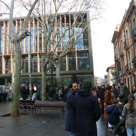 Diverses persones fent cua per accedir a la nova biblioteca de Sarrià.