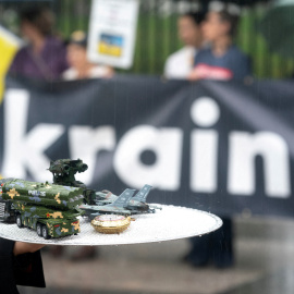 Un activista sostiene objetos que representan la venta de armas en Estados Unidos durante una manifestación frente a la Casa Blanca en Washington, (Estados Unidos).