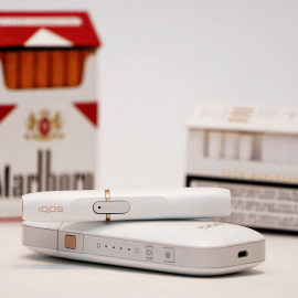 El cigarrillo electrónico Philip Morris iQOS, junto a una cajetilla de Marlboro.