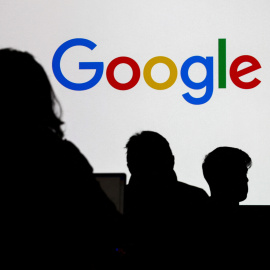 Tres personas frente a un logotipo de Google durante una recepción de prensa en la sede de Google Francia.