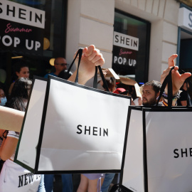 Dos personas sujetan dos bolsas de Shein después de entrar a la primera tienda física de SHEIN en una imagen de archivo.