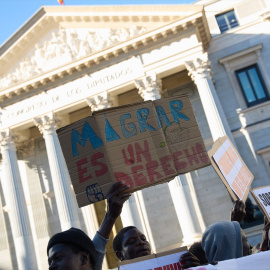 Varias personas se concentran frente al Congreso en defensa de la ILP de regularización de migrantes en abril de 2024.