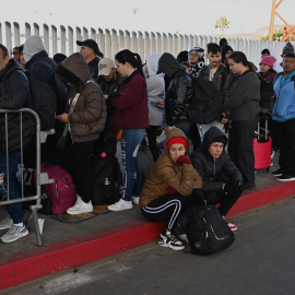 Solicitantes de asilo esperan sus citas en CBP One antes de cruzar por el puerto fronterizo de El Chaparral en Tijuana, México.
