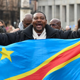 Un manifestante ondea la bandera de la República Democrática del Congo mientras participa en una manifestación de apoyo a la República Democrática del Congo, en Madrid.