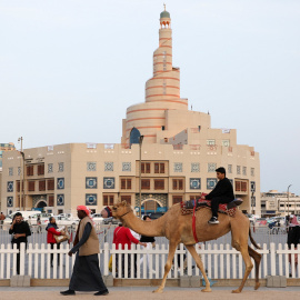 Un joven en camello pasa por el zoco de Souq Waqef, en Doha (Catar).