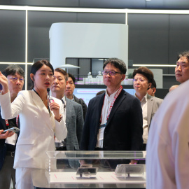 Una dona fa una explicació a un grup de congressistes durant el MWC