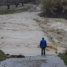 Un hombre junto a la carretera cortada por el desbordamiento del río Argos, Murcia, a 6 de marzo de 2025.