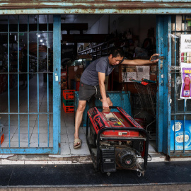 Una persona instala un generador eléctrico en su negocio durante el apagón este miércoles, en Buenos Aires (Argentina).