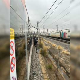 Viajeros andando por las vías del tramo de Rodalies entre Bellvitge y El Prat, en Barcelona, a 7 de marzo de 2025.