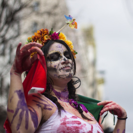 Una mujer, maquillada con un estilo similar al que utilizan los mexicanos en el Día de los Muertos, desfila durante la marcha del 8M por el centro de Madrid.