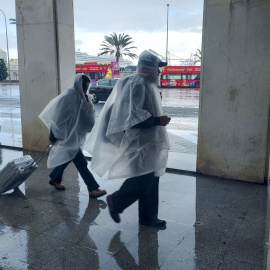 Varias personas se protegen de la lluvia en Cádiz, a 9 de marzo de 2025.