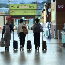 Pasajeros pasan por delante de quioscos de autofacturación en una terminal durante una huelga en el aeropuerto de Berlín, Alemania, el 10 de marzo de 2025.