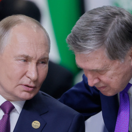 El presidente ruso, Vladímir Putin, habla con su asesor, Yuri Ushakov, durante una sesión plenaria en Kazán, a 24 de octubre de 2024.