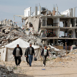 Hombres palestinos caminando cerca de escombros de casas destruidas durante la ofensiva israelí, en Rafah, en el sur de la Franja de Gaza, el 13 de marzo de 2025.